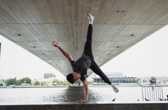 Un ragazzo esegue una verticale vicino a un fiume.